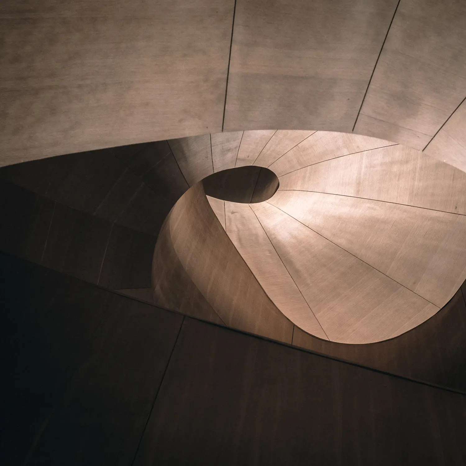Eine Treppe, die sich durch ihre spiralförmige Konstruktion auszeichnet, die sich um einen zentralen Mast oder eine Säule windet.